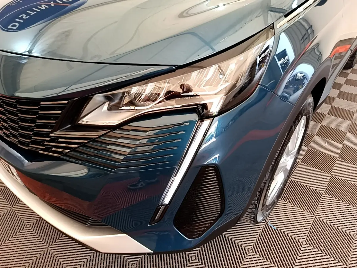 Gros plan sur l’avant droit bleu du Peugeot 3008 2022, mettant en valeur le phare LED et la calandre distinctive.