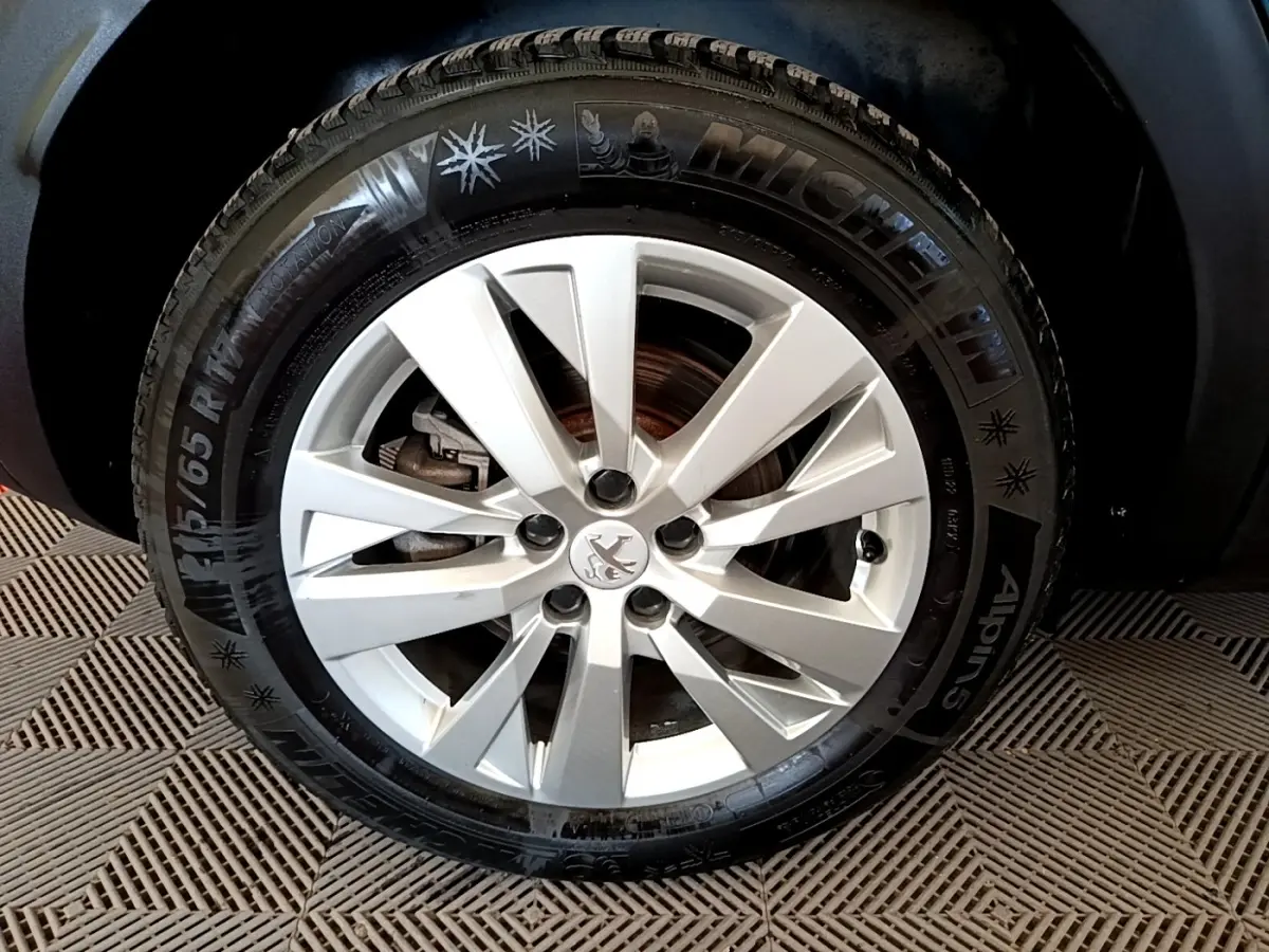 Gros plan sur la roue avant droite du Peugeot 3008 bleu, avec jante alliage argentée et pneu Michelin hiver.