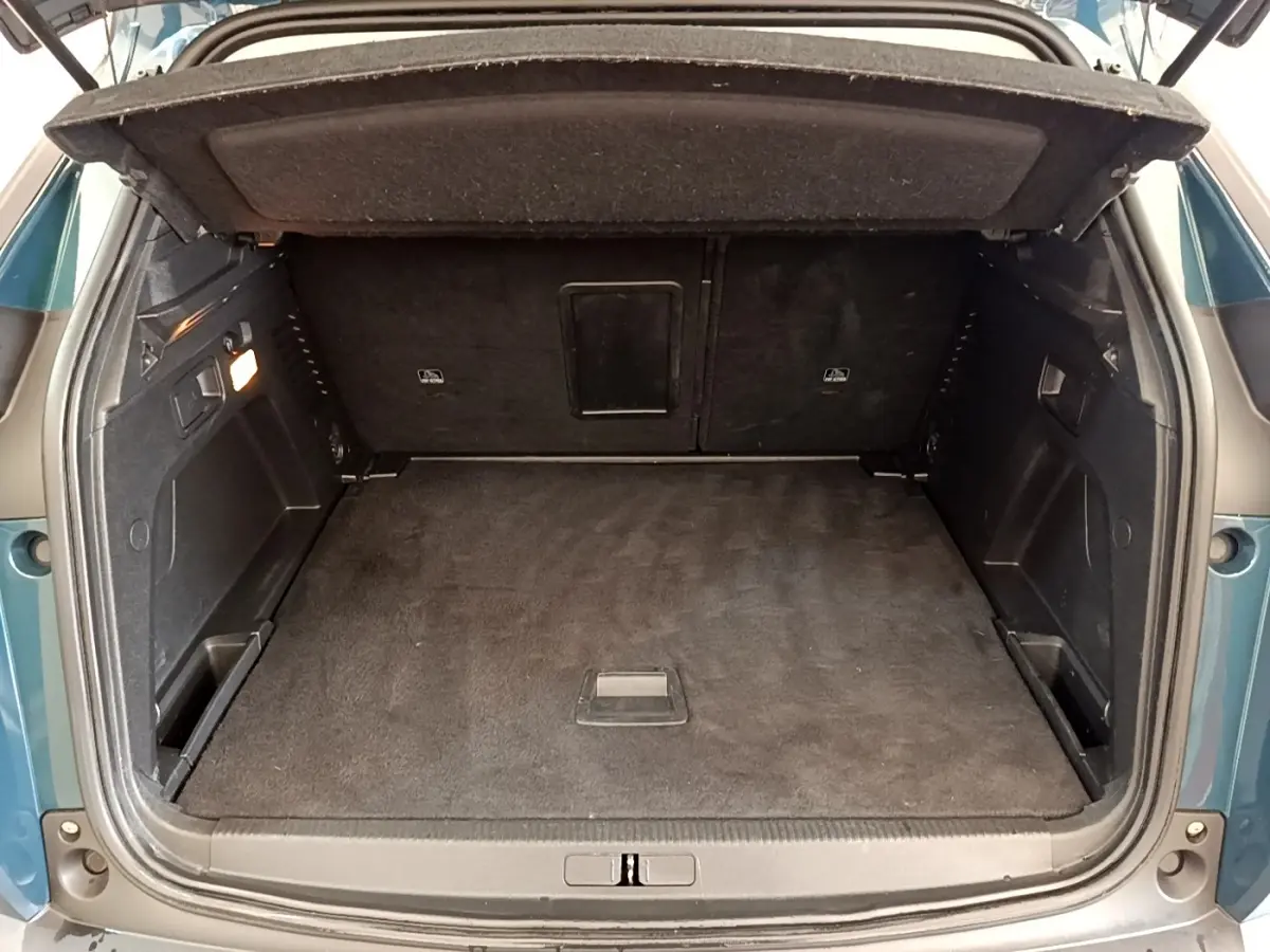 Coffre ouvert vu de l'arrière d'un Peugeot 3008 bleu 2022, montrant un espace de chargement propre et spacieux.