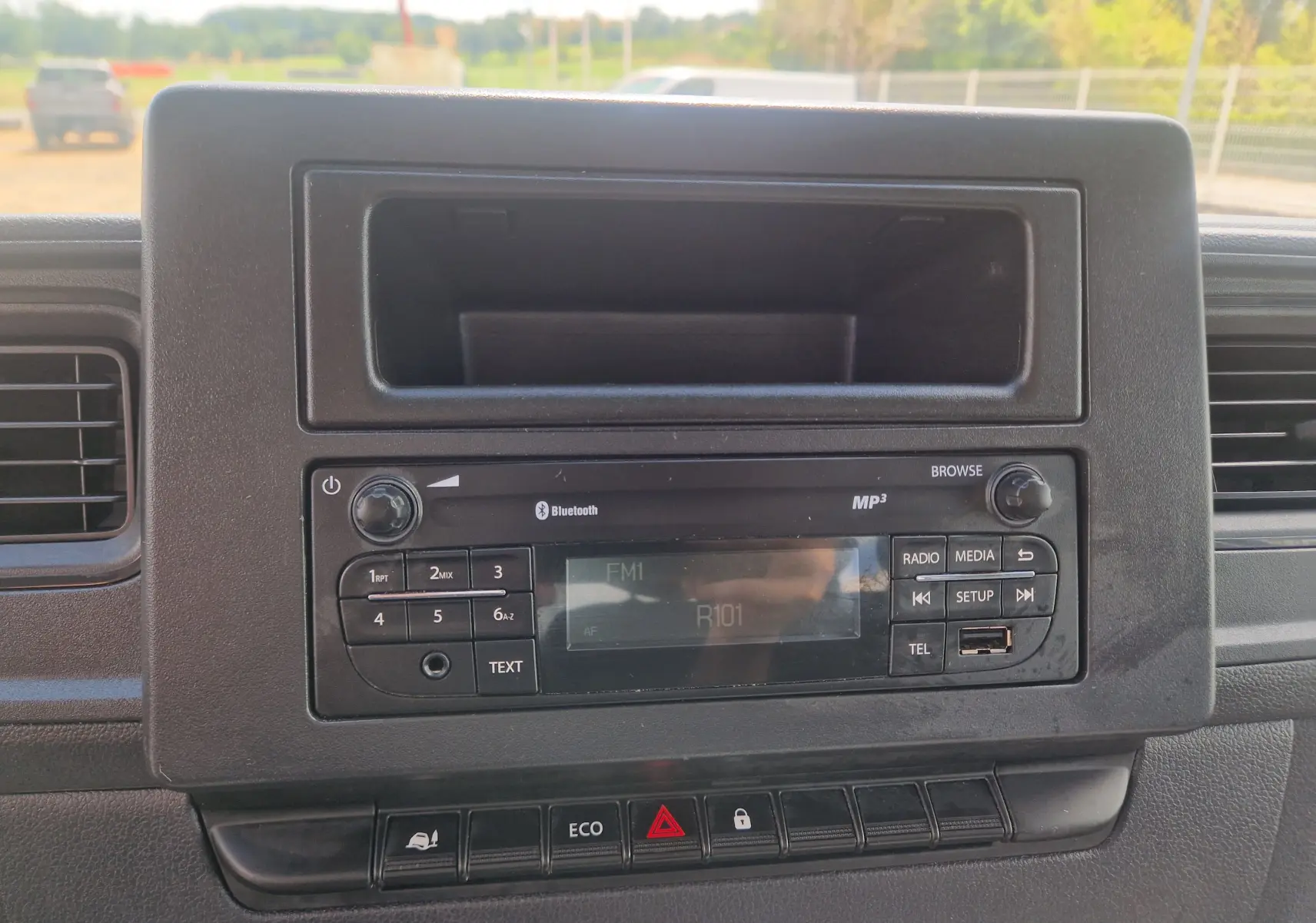 Tableau de bord du Renault Master Benne blanc 2024, vue frontale centrée sur la radio avec commandes et écran digital.