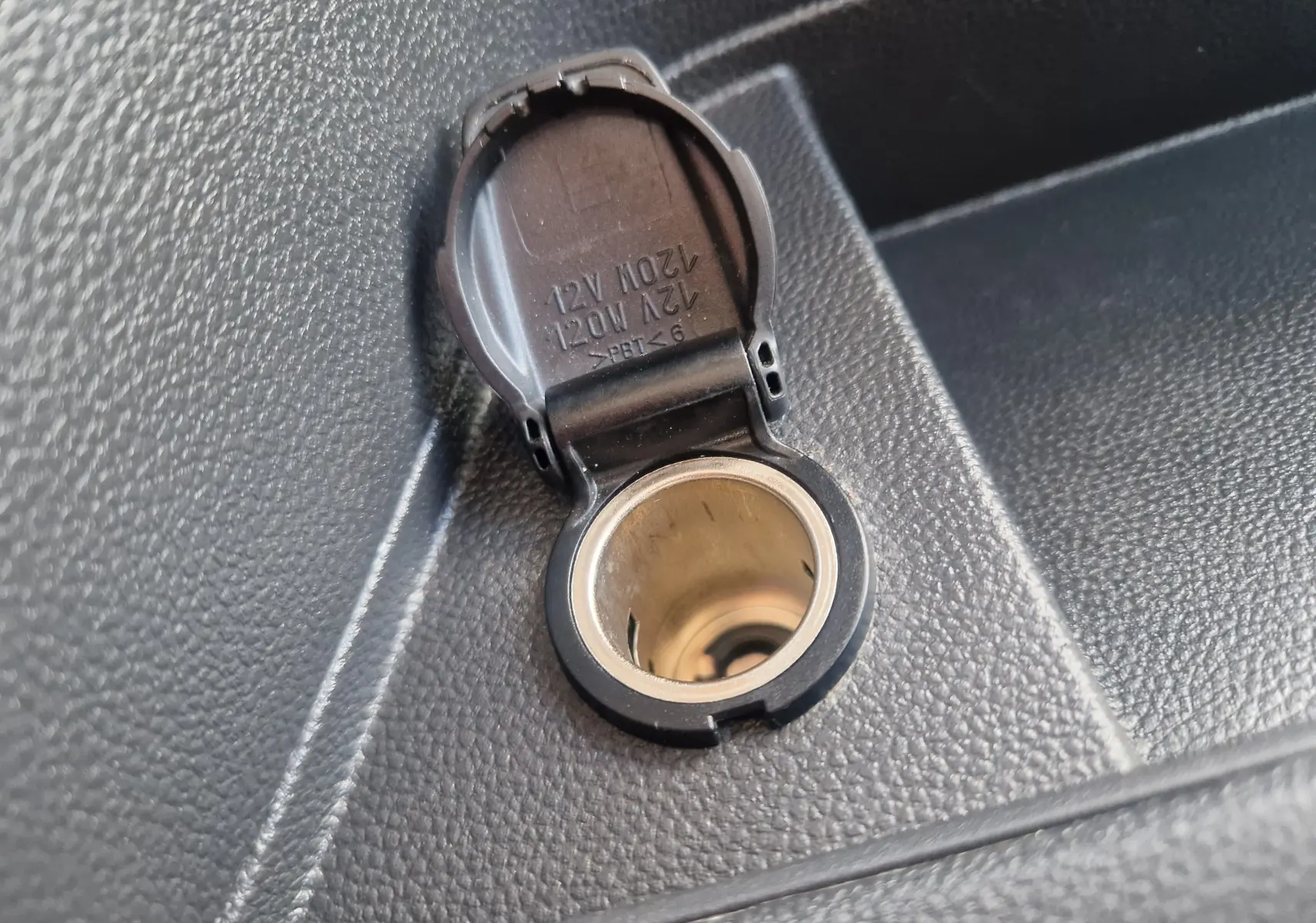 Gros plan sur la prise 12V ouverte dans l’habitacle du Renault Master Châssis Cabine blanc, version benne 2024.