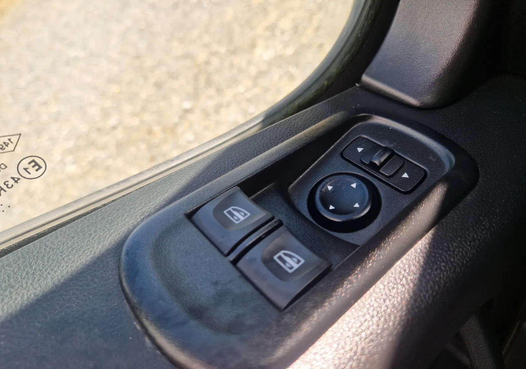 Gros plan sur les commandes électriques des vitres et réglage des rétroviseurs côté conducteur du Renault Master blanc 2024.