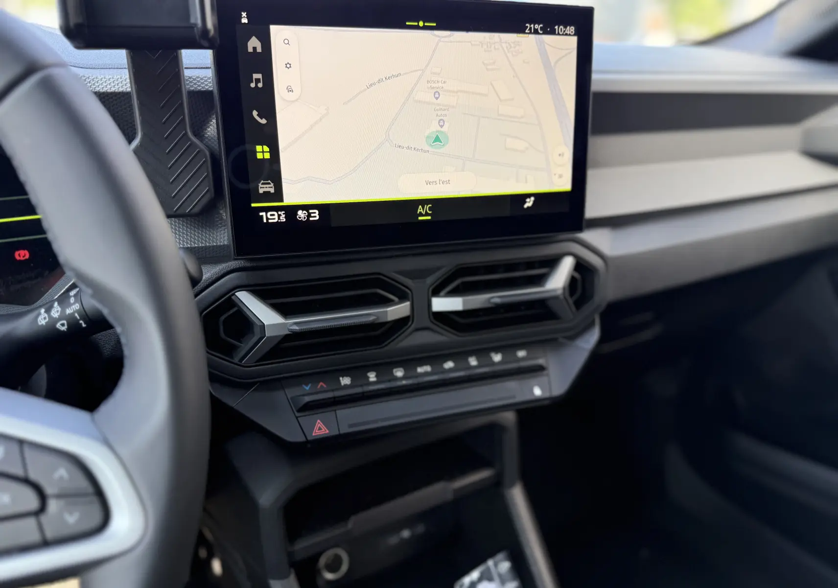 Vue intérieure du tableau de bord du Dacia Duster Hybrid 155 Journey 2026, écran tactile avec navigation et aérateurs hexagonaux.