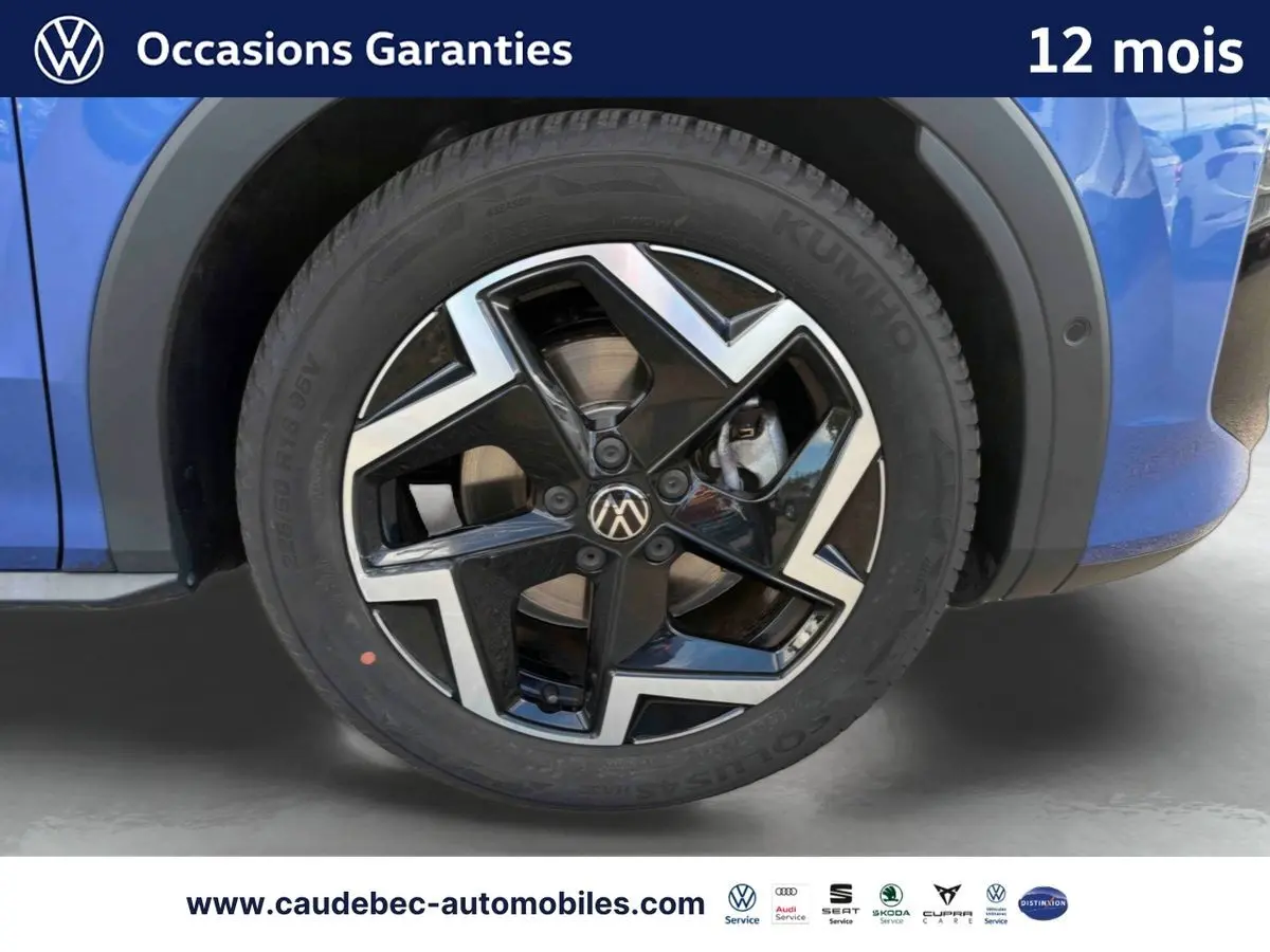 Gros plan sur la roue avant droite du Volkswagen T-Roc bleu avec jante alliage noir et argent Coventry.