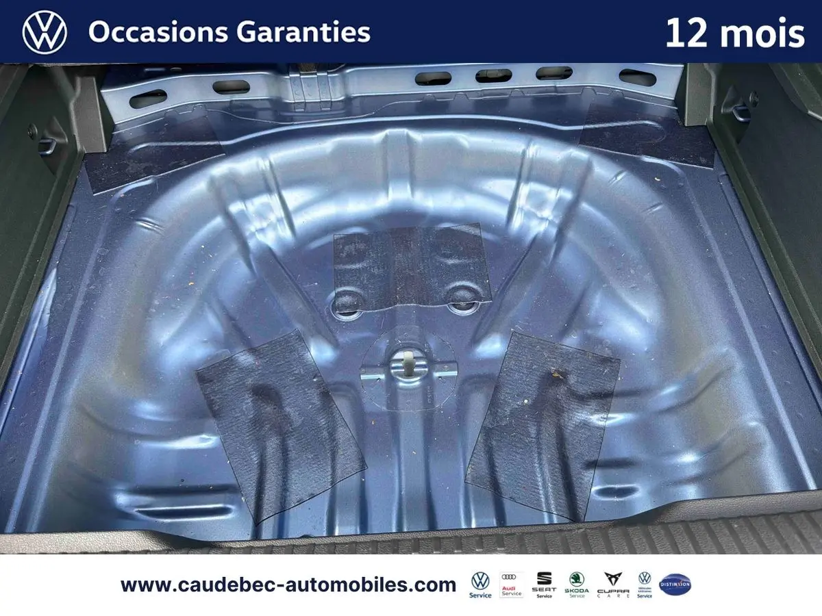 Coffre ouvert en vue plongeante montrant la cuve métallique bleue du Volkswagen T-Roc 2026 sans roue de secours.