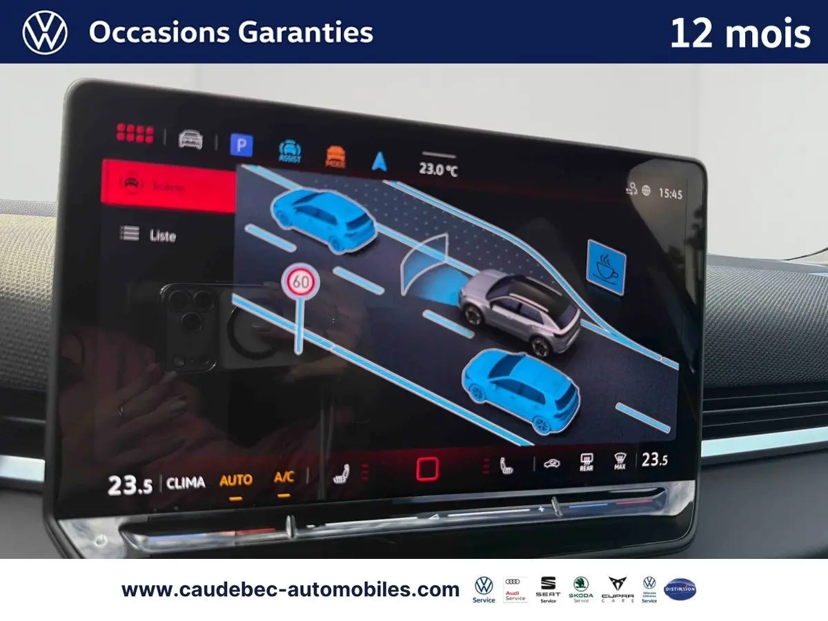 Écran tactile intérieur du Volkswagen T-Roc bleu montrant l’assistance au maintien de voie et la limitation de vitesse à 60 km/h.