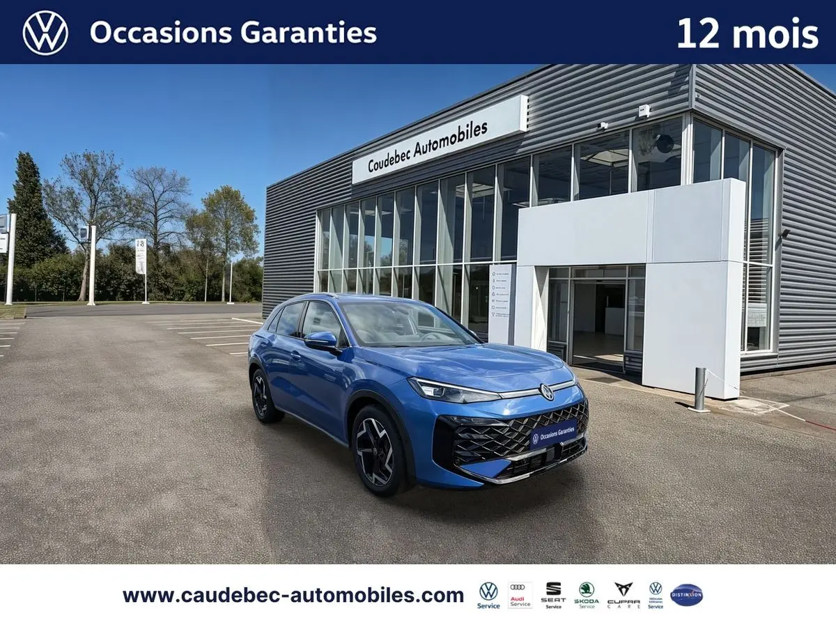 Volkswagen T-Roc bleu métallisé en 3/4 avant droit, avec jantes noires brillantes, devant un showroom moderne.