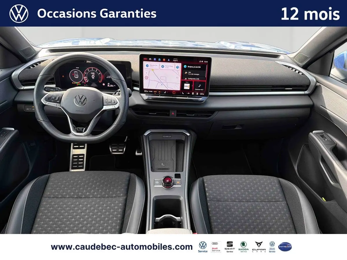 Vue intérieure avant du Volkswagen T-Roc 2026 avec tableau de bord noir et écran tactile central lumineux.