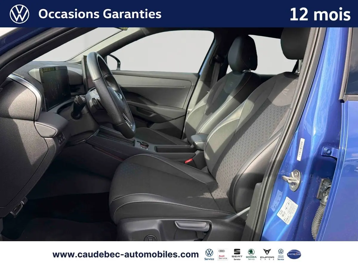 Intérieur du Volkswagen T-Roc bleu 2026, vue côté conducteur avec sièges sport noirs et volant multifonction cuir.