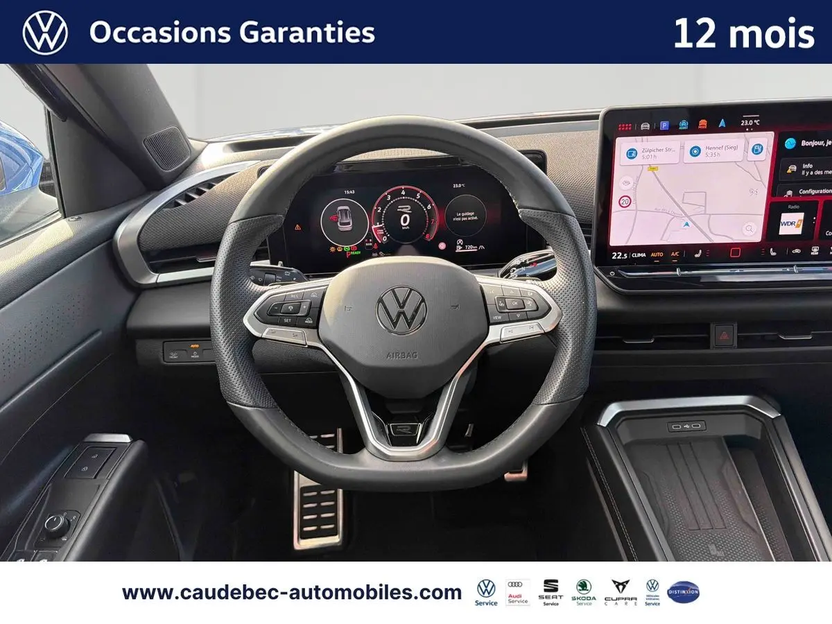 Vue intérieure centrée sur le volant multifonction cuir du Volkswagen T-Roc 2026 avec tableau de bord numérique et écran tactile.