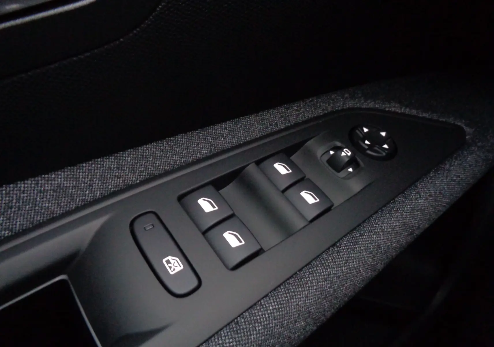 Panneau de commandes des vitres électriques et rétroviseurs sur la porte côté gauche du Peugeot 3008 gris Artense 2023.