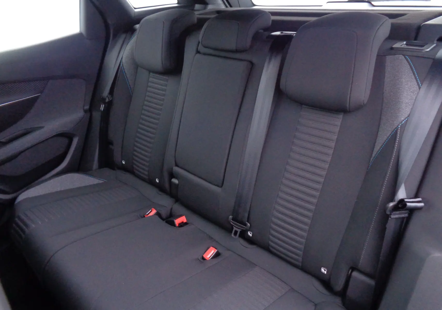 Vue intérieure de la banquette arrière noire du Peugeot 3008 2023 avec appuie-têtes et ceintures visibles.
