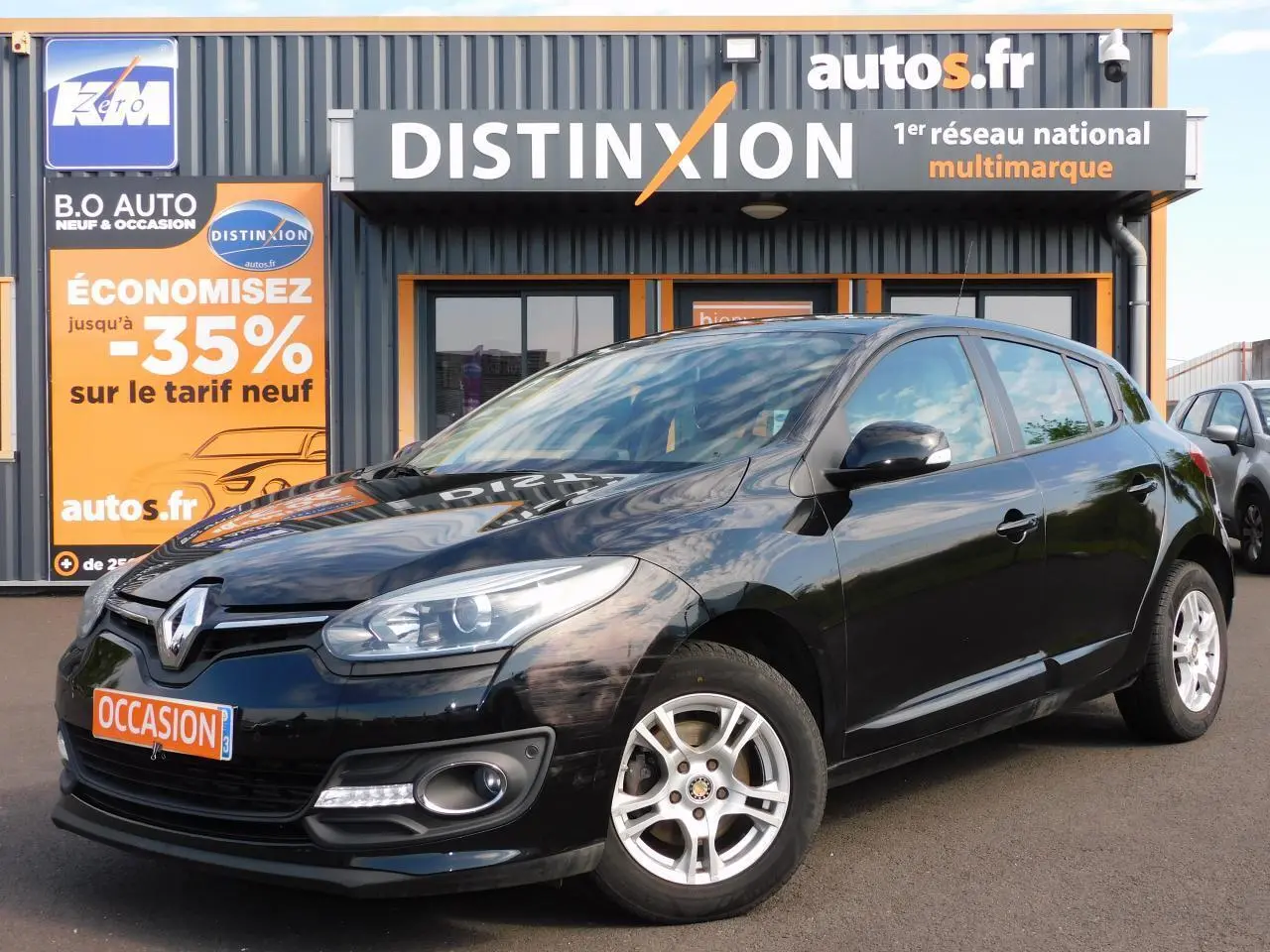 Renault Mégane noire vue en 3/4 avant droit, avec phares allumés et jantes alliage argentées.