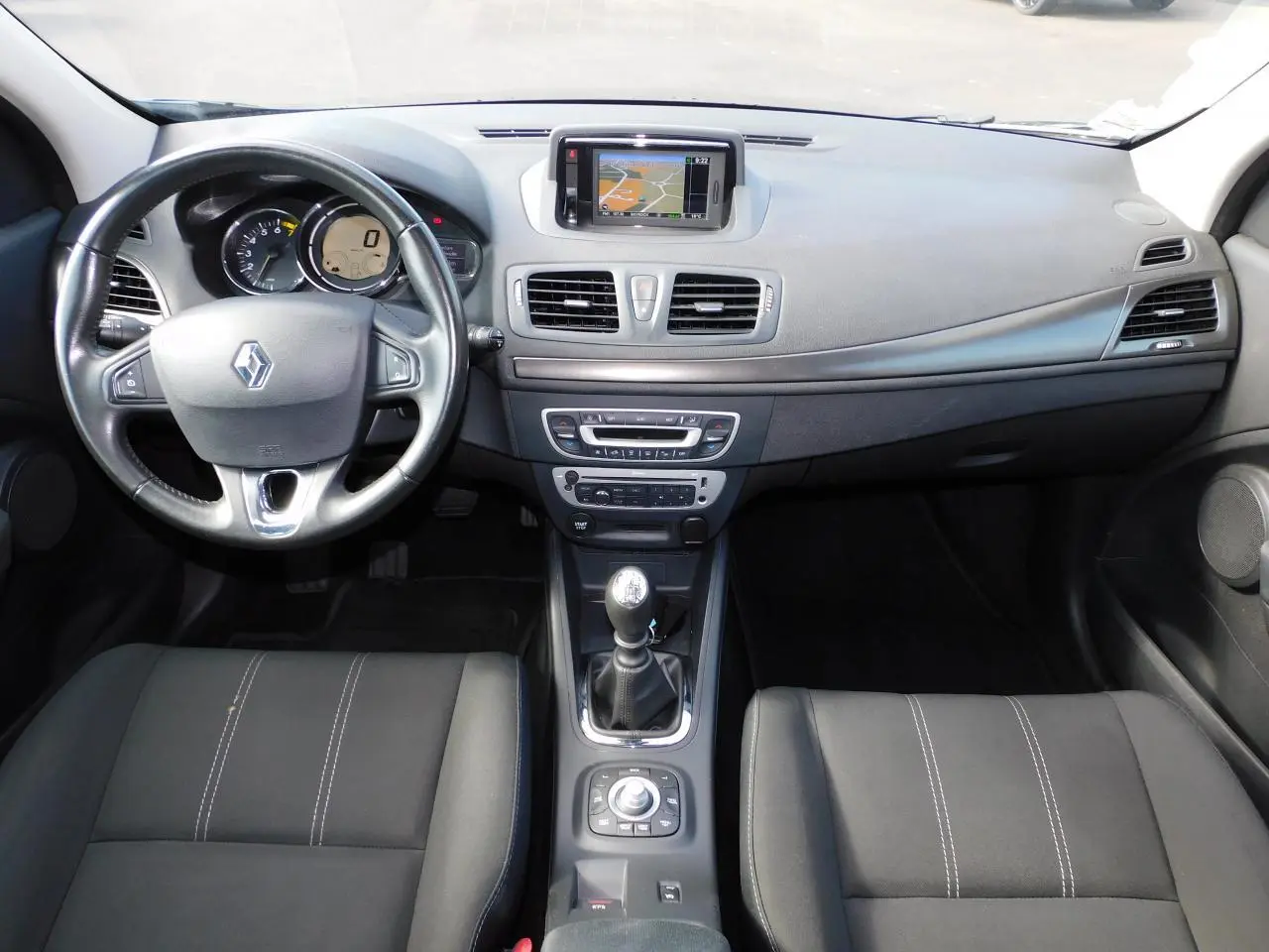 Vue intérieure avant de la Renault Mégane noire de 2015, avec tableau de bord et écran GPS central visible.