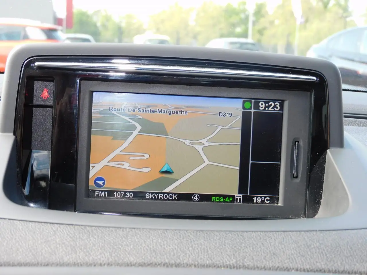 Écran GPS Carminat TomTom affichant une carte routière dans l'habitacle de la Renault Mégane noire de 2015.