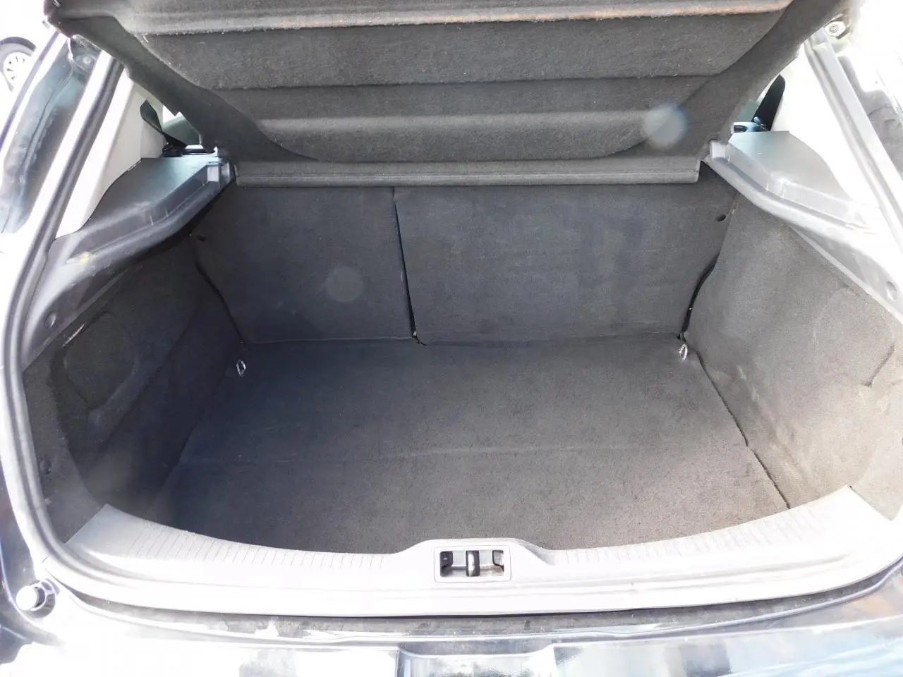 Coffre ouvert de la Renault Mégane noire de 2015, montrant un espace de chargement propre et spacieux.