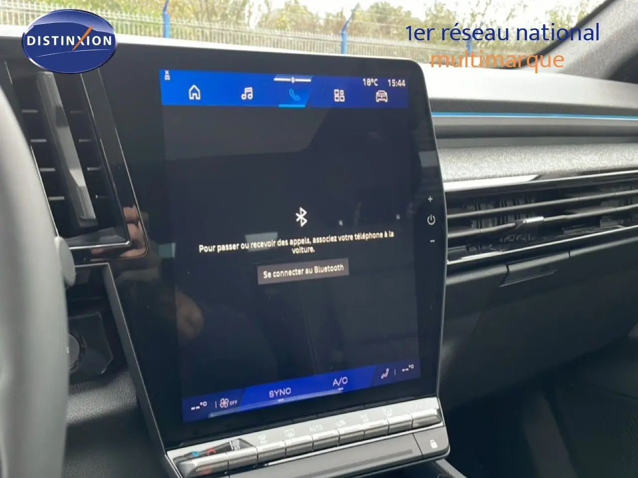 Écran tactile central du tableau de bord du Renault Espace 2025, finition noire avec commandes climatisation visibles.