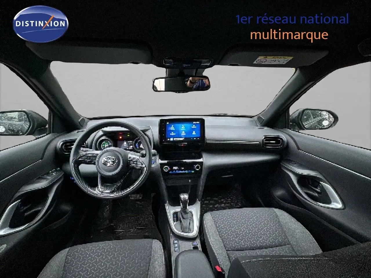 Intérieur noir de la Toyota Yaris Cross 2023 vu de face, avec tableau de bord numérique et écran tactile central.