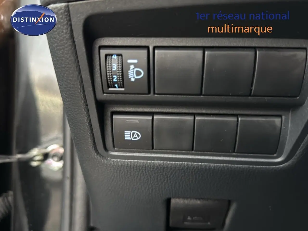 Gros plan sur les commandes d'éclairage du tableau de bord d'une Toyota Yaris Cross 116h Design noire de 2023.