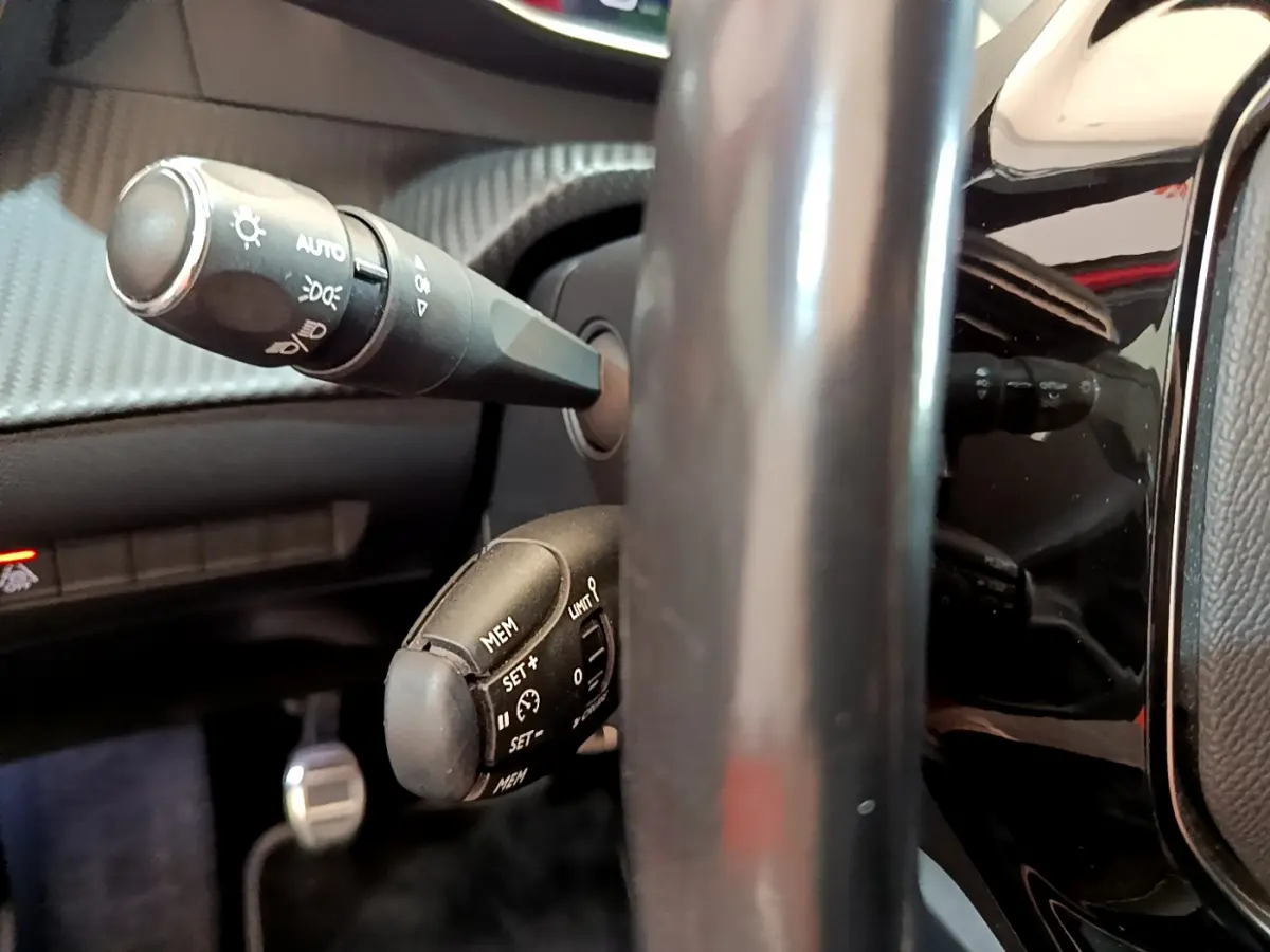 Gros plan sur les commandes au volant du Peugeot 208 GT Line 2020, avec levier de clignotants et régulateur de vitesse.