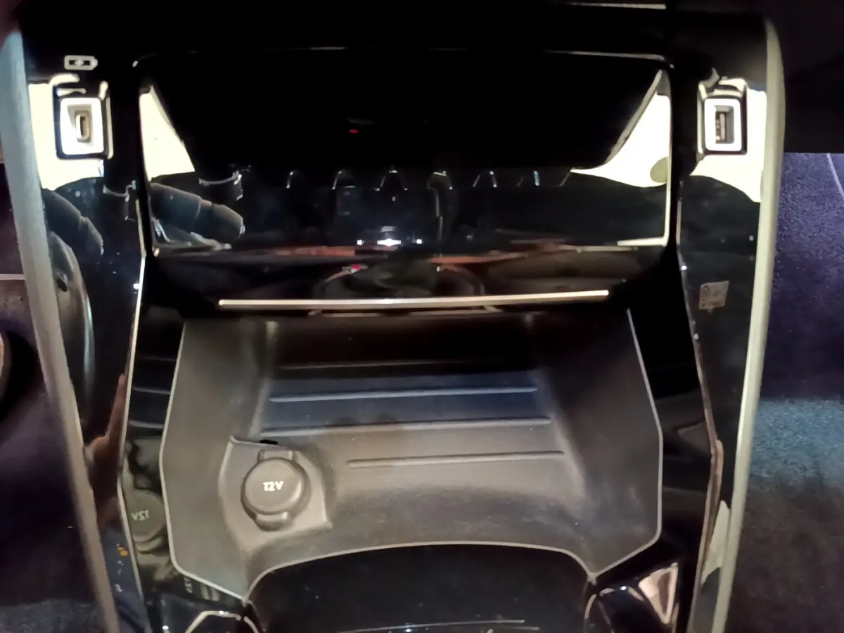 Gros plan sur la console centrale noire de la Peugeot 208 GT Line 2020 avec prise 12V visible.