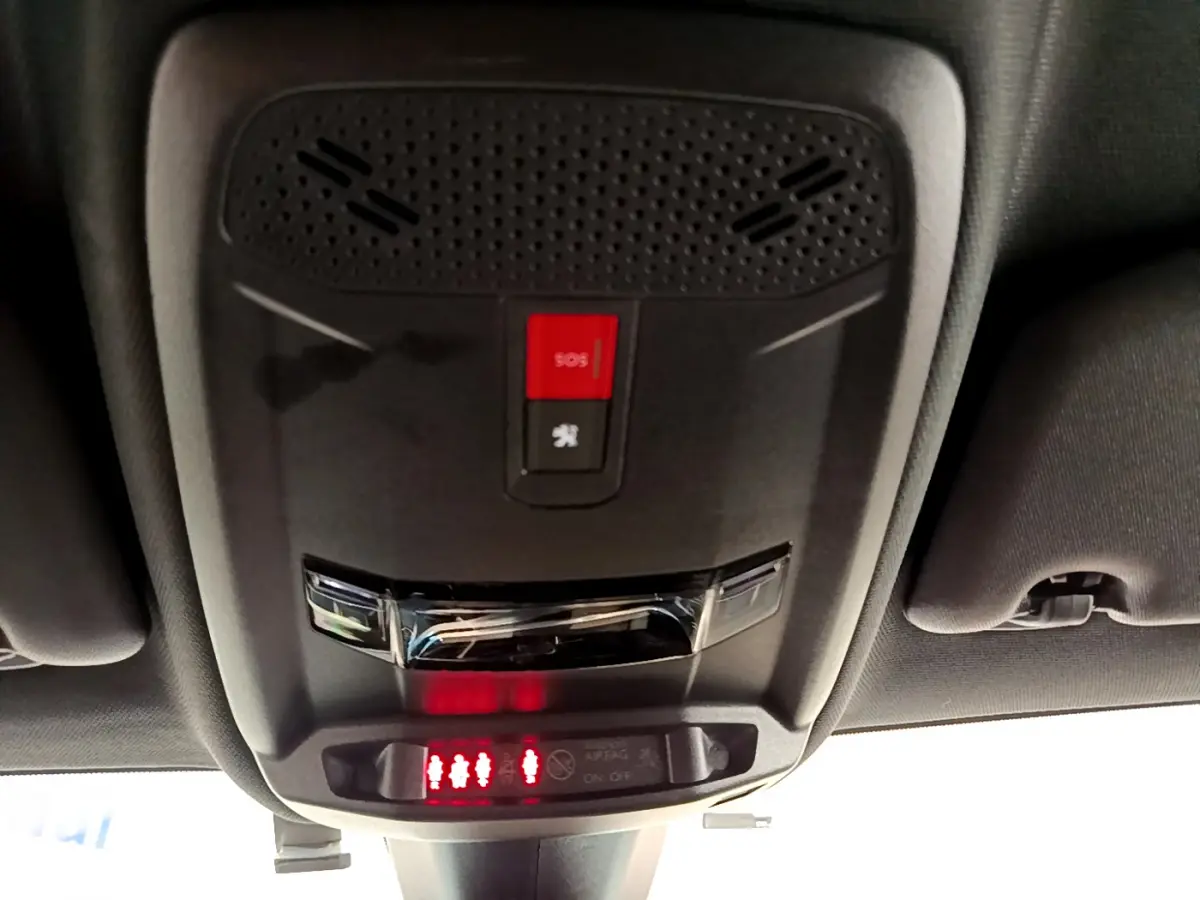 Vue en gros plan du plafonnier intérieur avec bouton SOS rouge et indicateurs de ceinture du Peugeot 208 rouge GT Line 2020