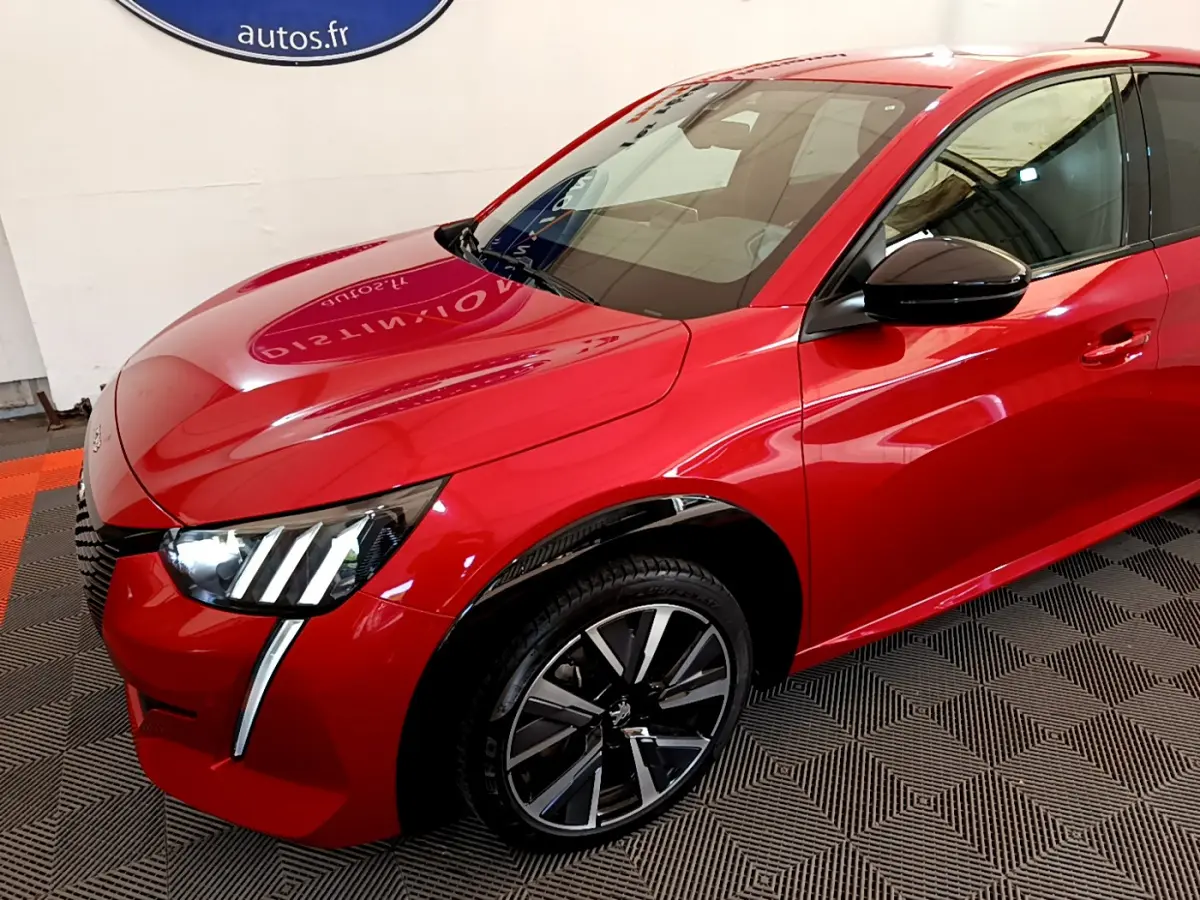 Vue 3/4 avant gauche d'une Peugeot 208 GT Line rouge avec phares LED et jantes alliage noires.