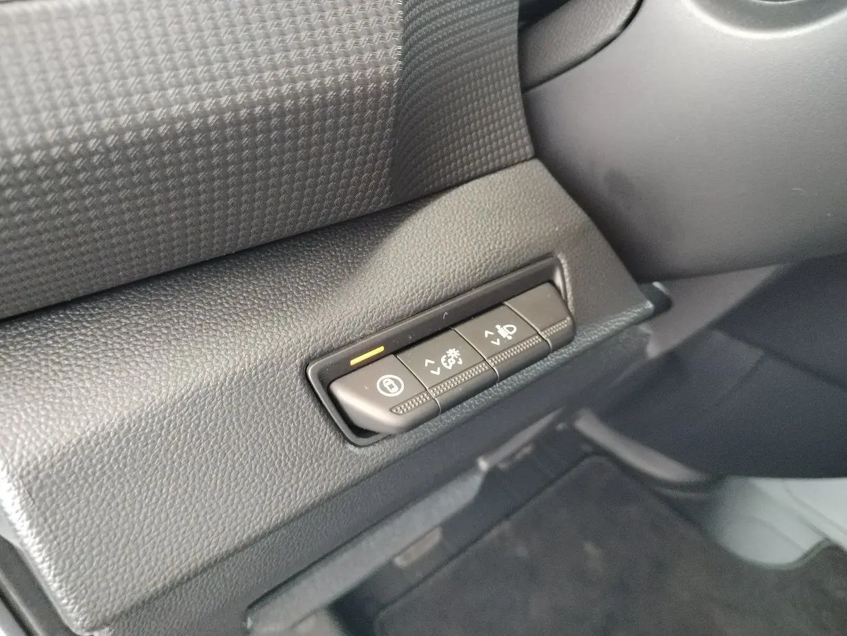 Gros plan sur les boutons de réglage du tableau de bord noir du Nissan Primastar blanc, version 2025.