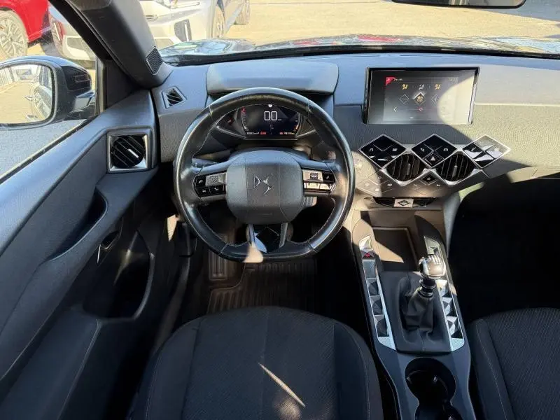 Vue intérieure frontale du tableau de bord noir du DS3 Crossback 2020 avec volant multifonction et écran tactile central.
