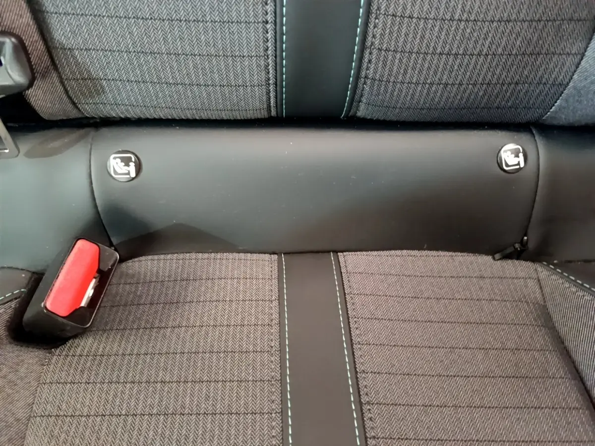 Détail de la banquette arrière grise avec surpiqûres bleues et attaches Isofix visibles sur Peugeot 208 PureTech 100.