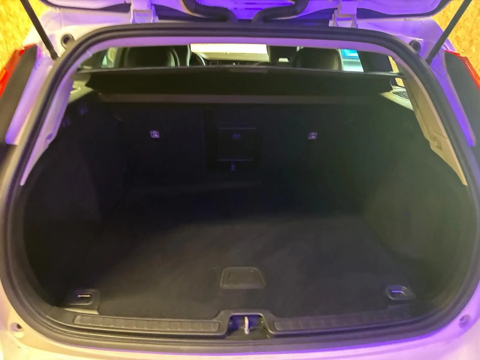 Coffre ouvert d’un Volvo V60 blanc 2020, vue arrière montrant un espace de chargement vide et propre.