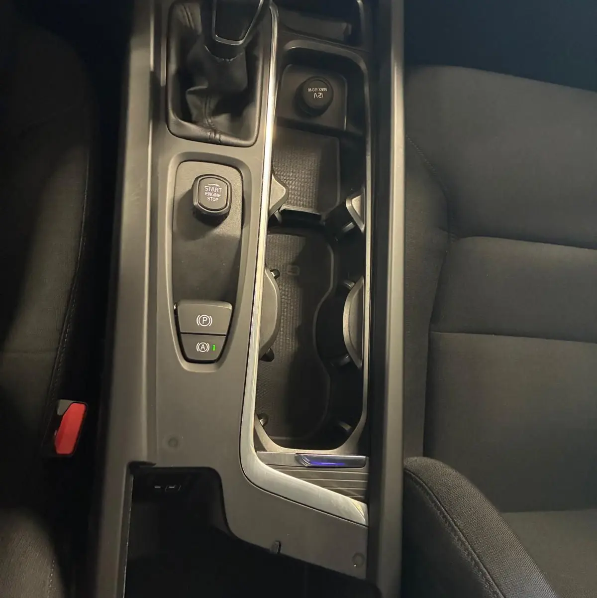 Vue plongeante sur la console centrale noire d’une Volvo V60 D3 2020, avec levier de vitesse manuel et boutons de démarrage.