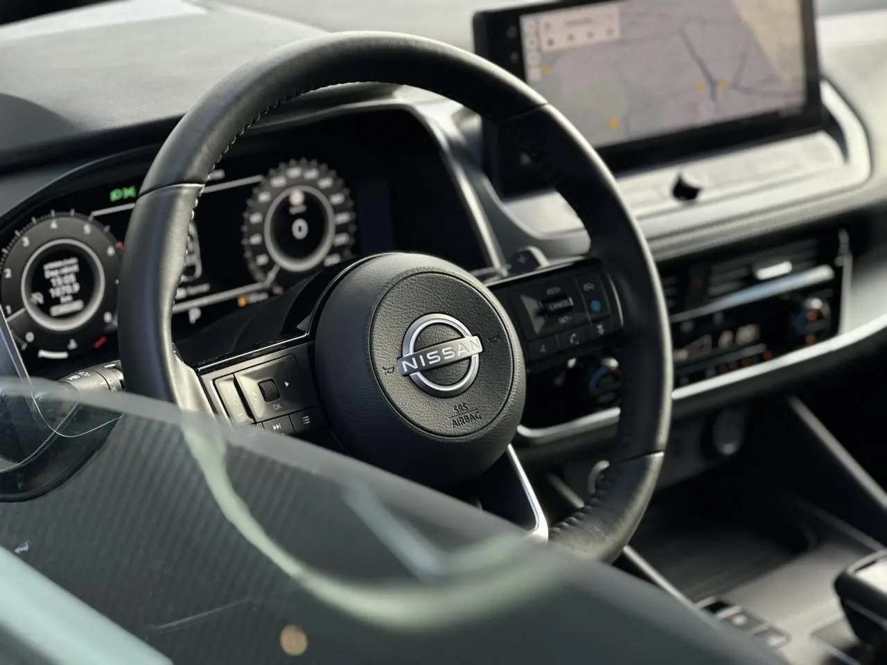 Vue rapprochée du volant noir en cuir et du tableau de bord numérique du Nissan Qashqai 2025.