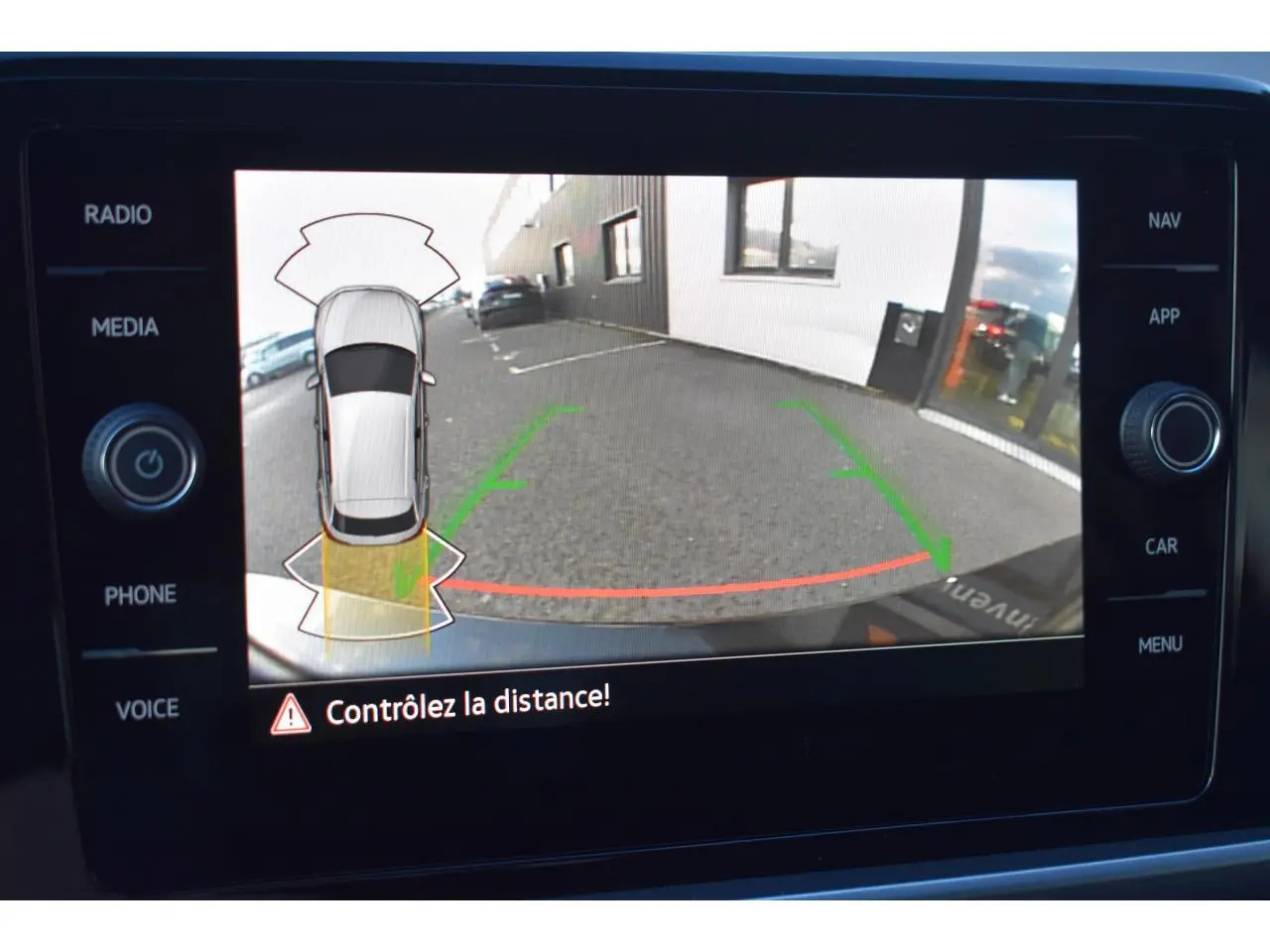 Écran de caméra de recul du Volkswagen T-Roc 2025 montrant l'arrière du véhicule et les lignes de guidage au parking.