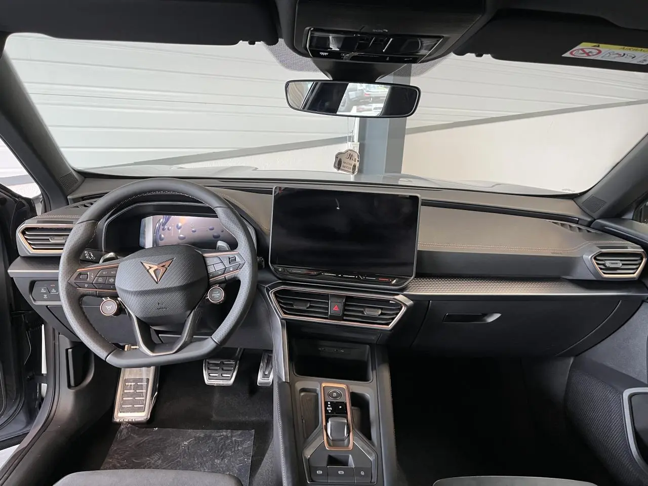 Intérieur avant du CUPRA Formentor gris clair 2025, volant cuir avec logo cuivré et écran tactile central HD.