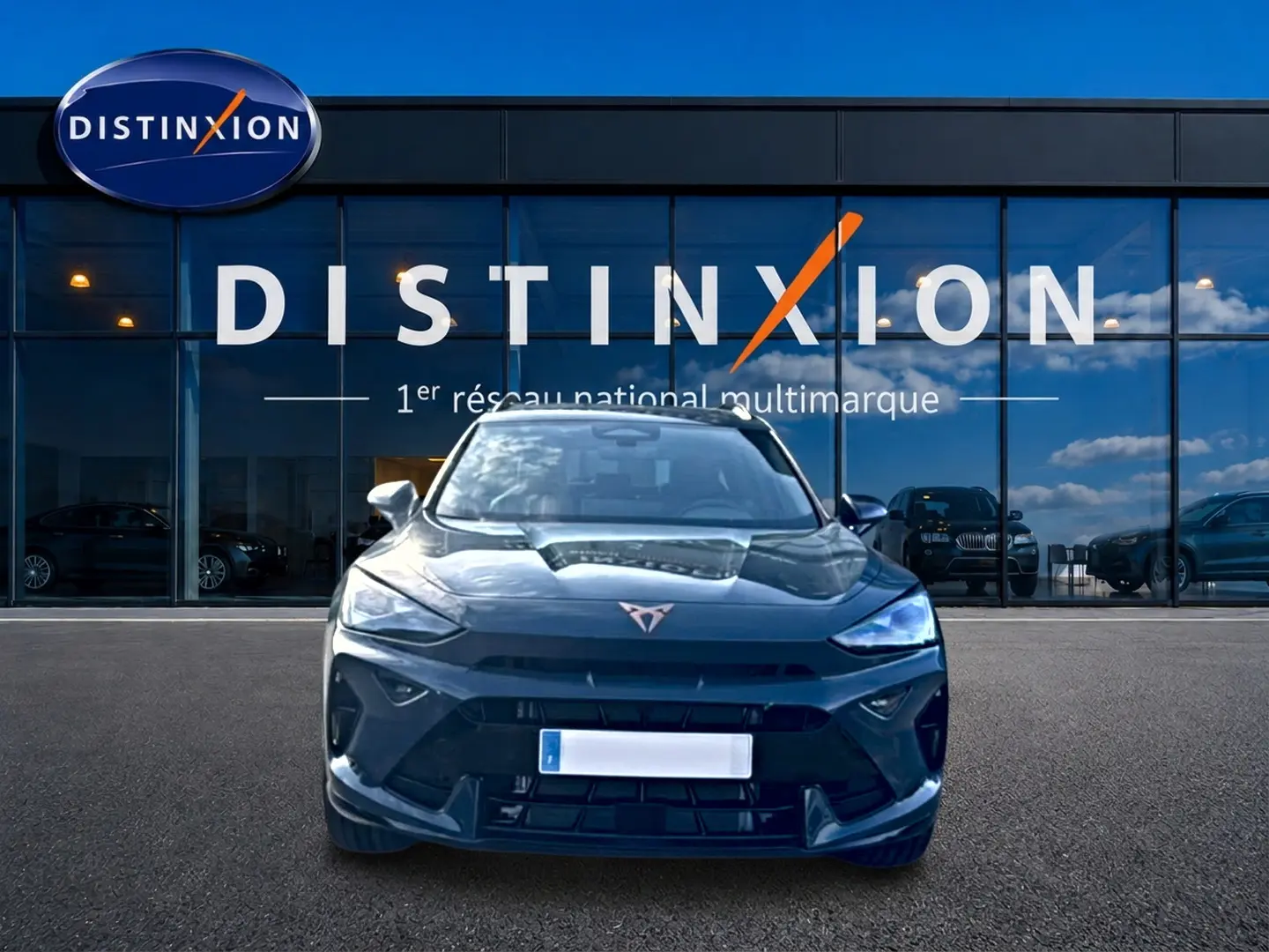 Vue avant d'un CUPRA Formentor bleu fjord 2026, avec logo distinctif et calandre sportive, devant une vitrine Distinxion.