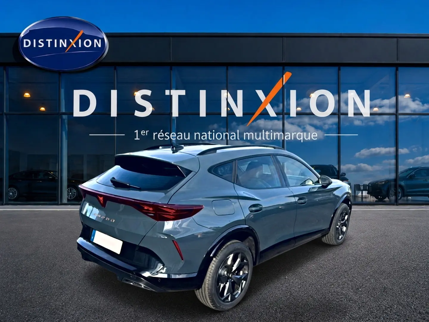 Vue 3/4 arrière droite d'une CUPRA Formentor bleu fjord avec jantes noires devant une vitrine Distinxion.