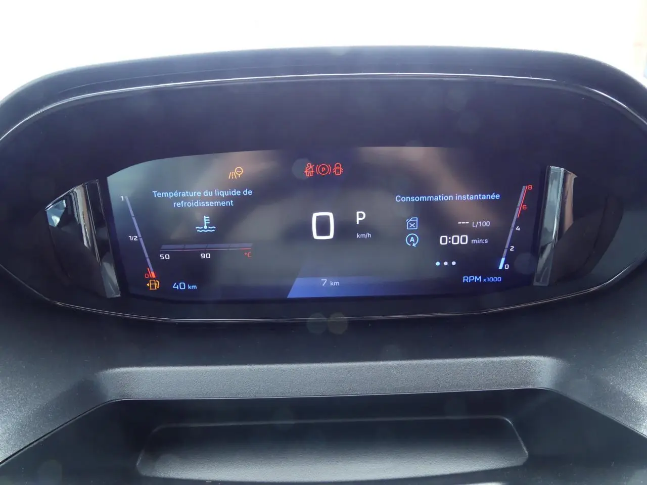 Affichage numérique du combiné de bord du Peugeot Partner 2025, avec indicateurs de vitesse, température et consommation.