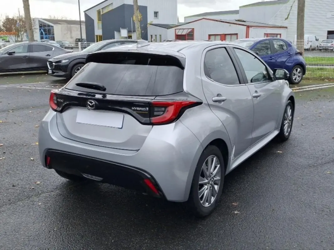 Vue 3/4 arrière droite d'une Mazda2 Hybrid argent 2022 avec feux arrière distinctifs et vitre arrière teintée.