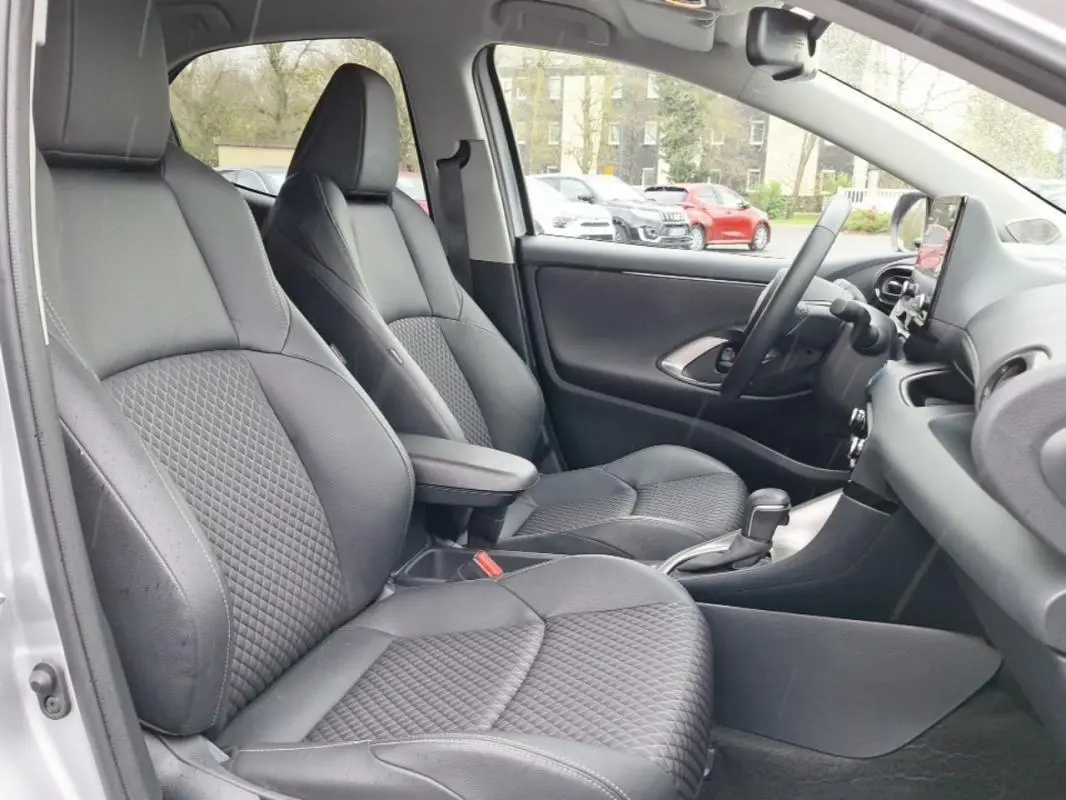 Vue intérieure côté gauche de la Mazda2 Hybrid 2022 avec sièges avant en cuir noir et console centrale visible.