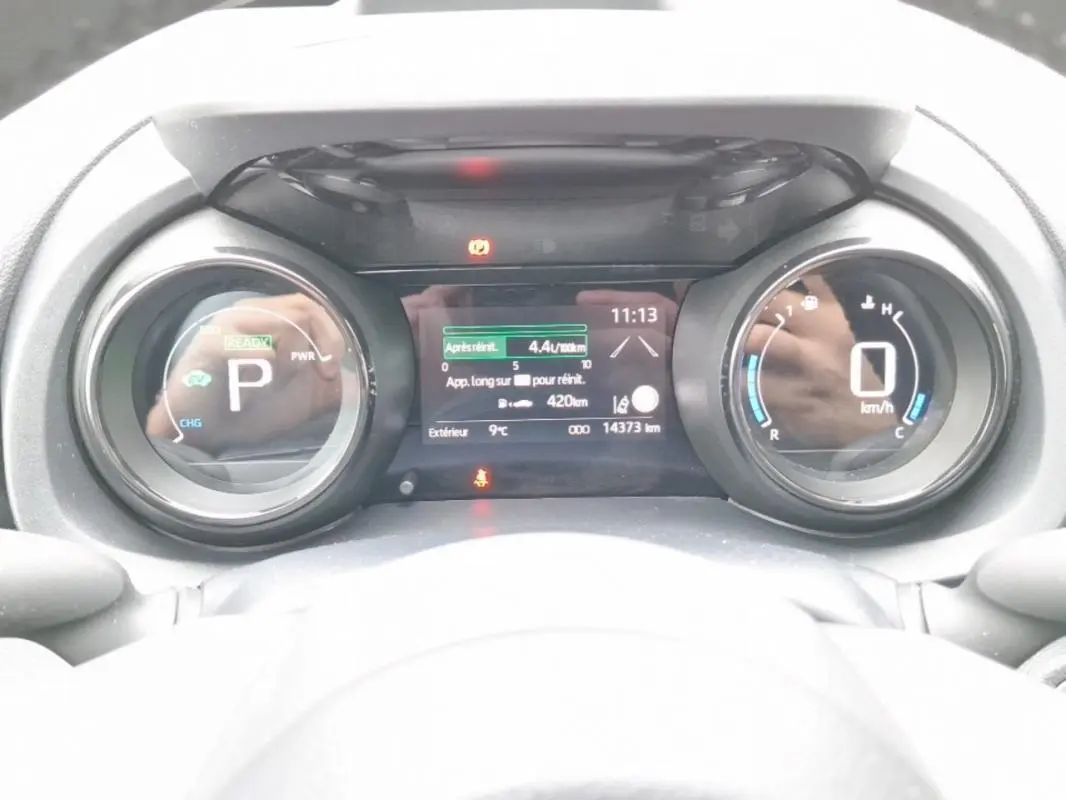 Tableau de bord numérique de la Mazda2 Hybrid 2022, affichant la vitesse à 0 km/h et la consommation instantanée.