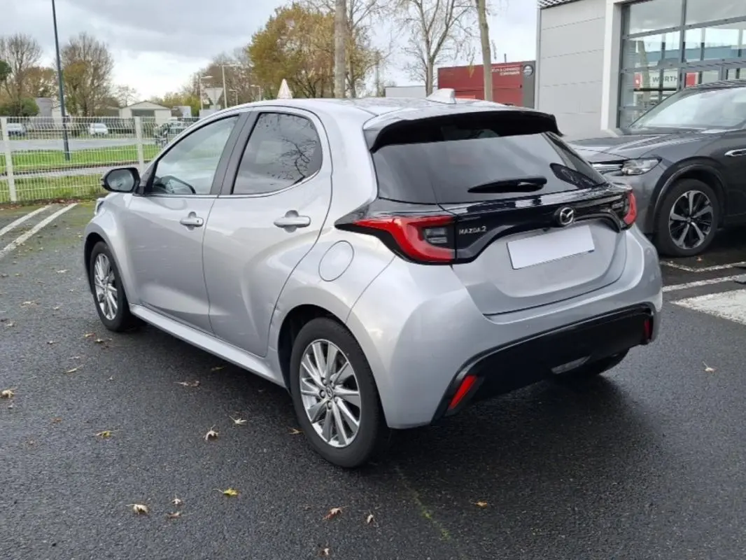 Vue 3/4 arrière droite d'une Mazda2 hybride 2022 argent avec vitres teintées et feux arrière distinctifs.