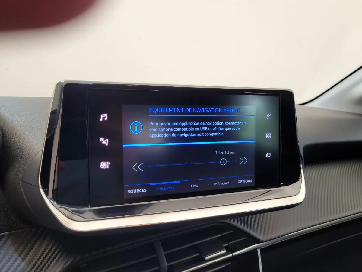 Écran tactile central allumé du tableau de bord d'une Peugeot 208 gris foncé, version BlueHDi 2023.