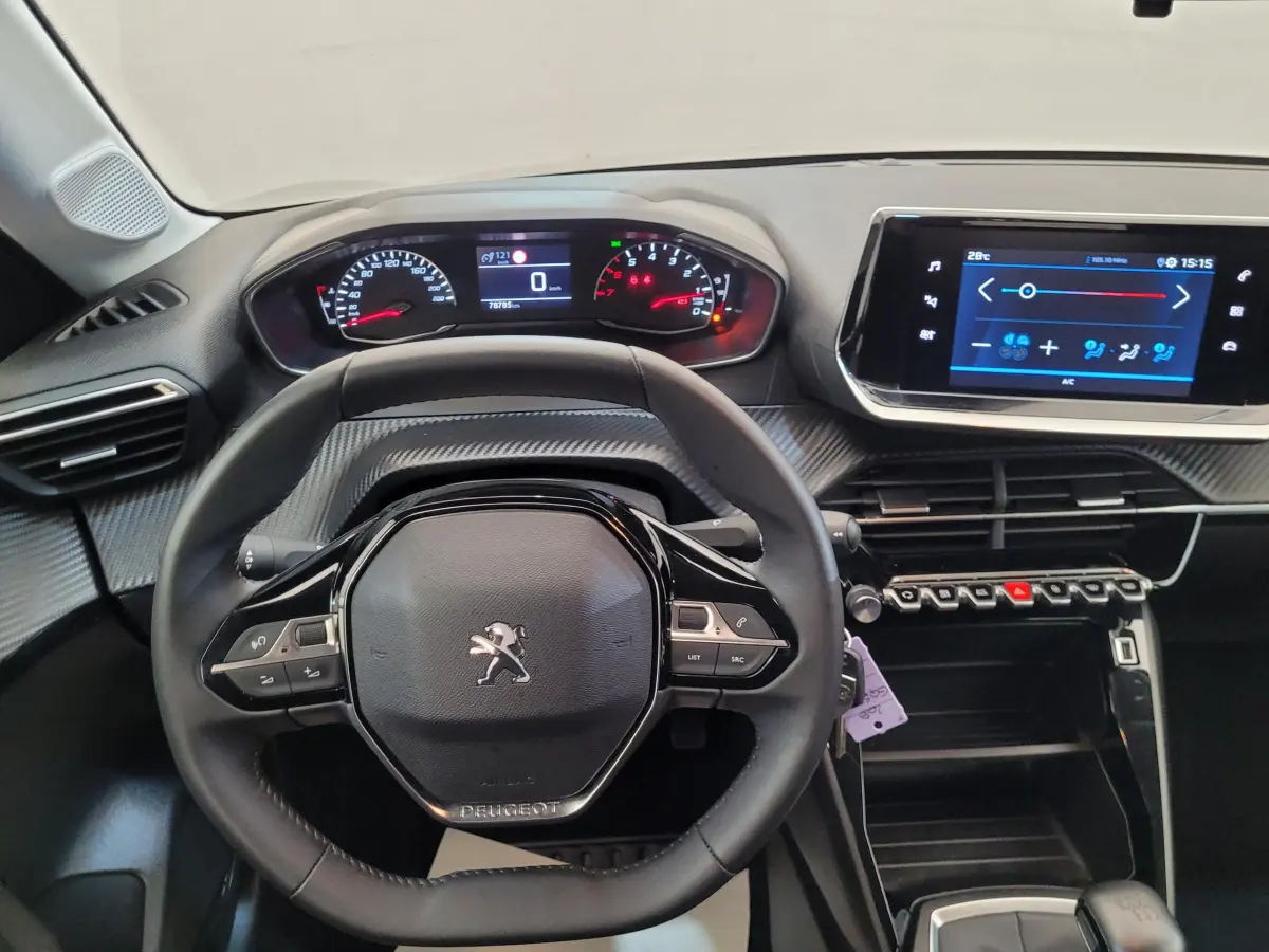 Vue intérieure centrée sur le volant cuir et tableau de bord numérique de la Peugeot 208 2023 gris foncé.