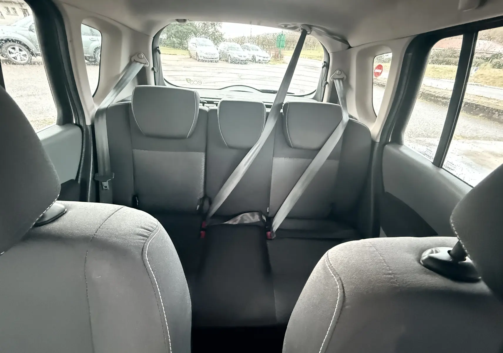 Vue intérieure arrière montrant les sièges arrière gris-noir en tissu d'une Renault Modus beige de 2011.