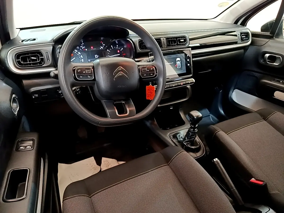 Vue intérieure avant de la Citroën C3 2021, tableau de bord noir avec écran tactile et volant multifonctions.