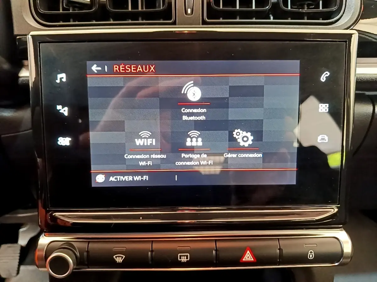 Écran tactile central de la Citroën C3 blanc, affichant les options de connexion Bluetooth et Wi-Fi, vue de face rapprochée.