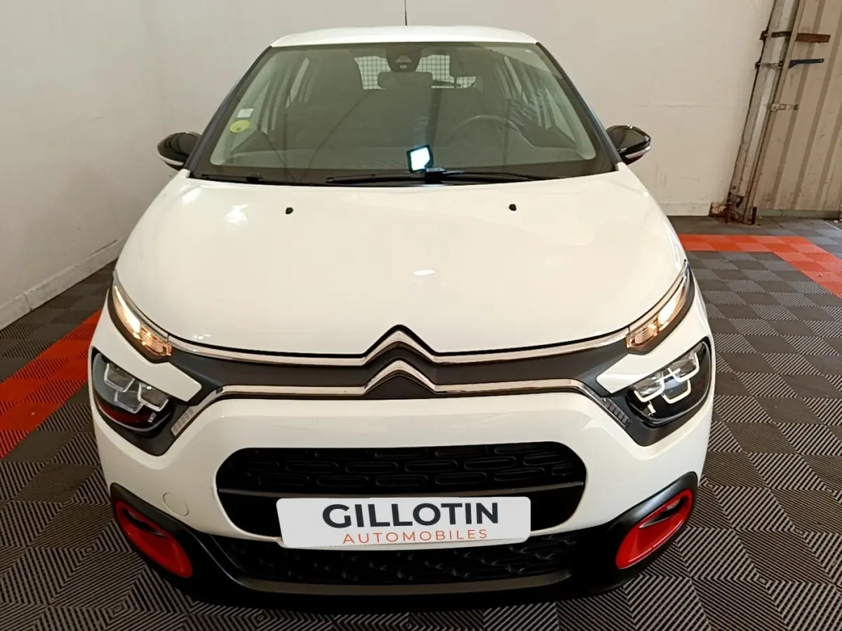 Vue avant d'une Citroën C3 blanche 2021 avec phares LED et détails rouges sur le pare-chocs.