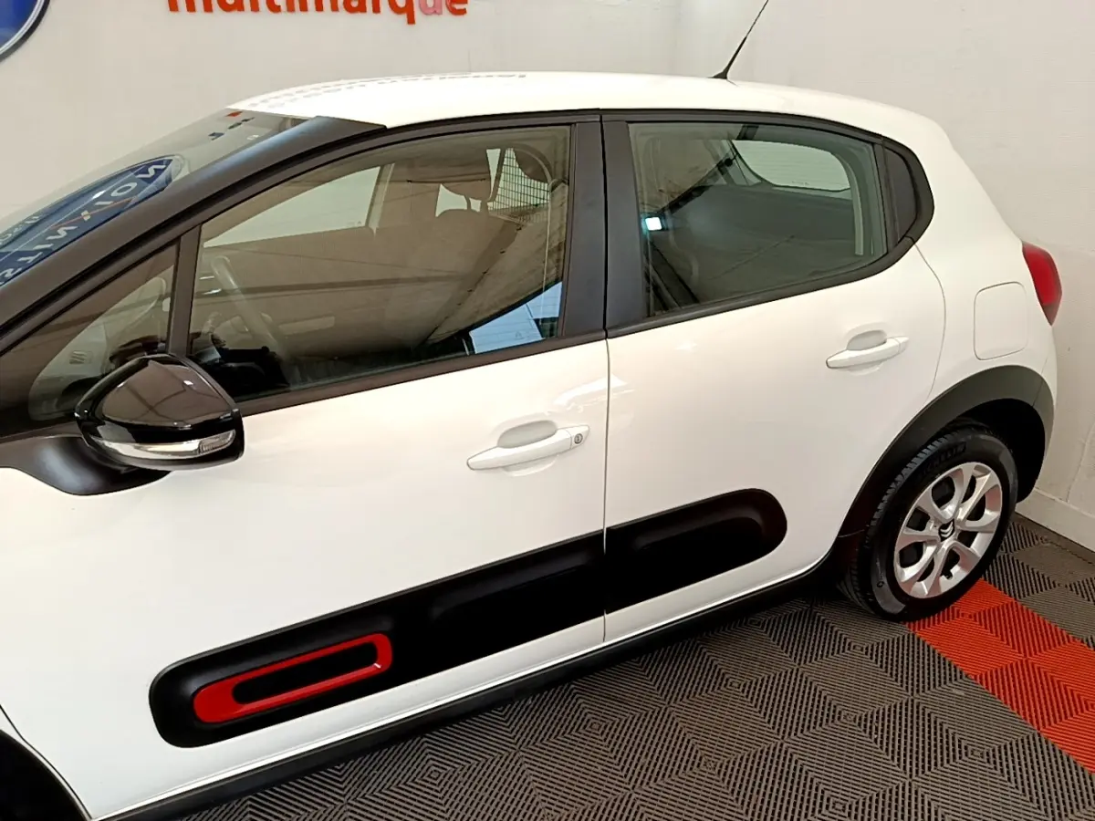 Vue latérale droite d'une Citroën C3 blanche 2021 avec protection latérale noire et insert rouge sur porte.