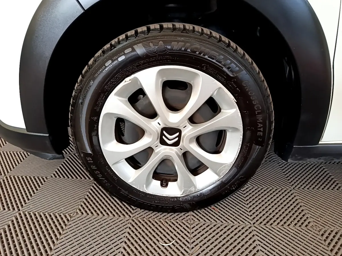 Gros plan sur la roue avant droite blanche d'une Citroën C3 2021 avec jante en alliage et logo Citroën au centre.